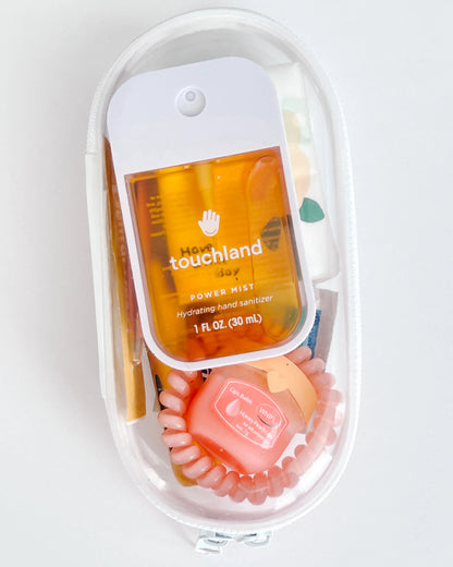 Everyday Essentials Kit filled with travel-size must-haves in orange.