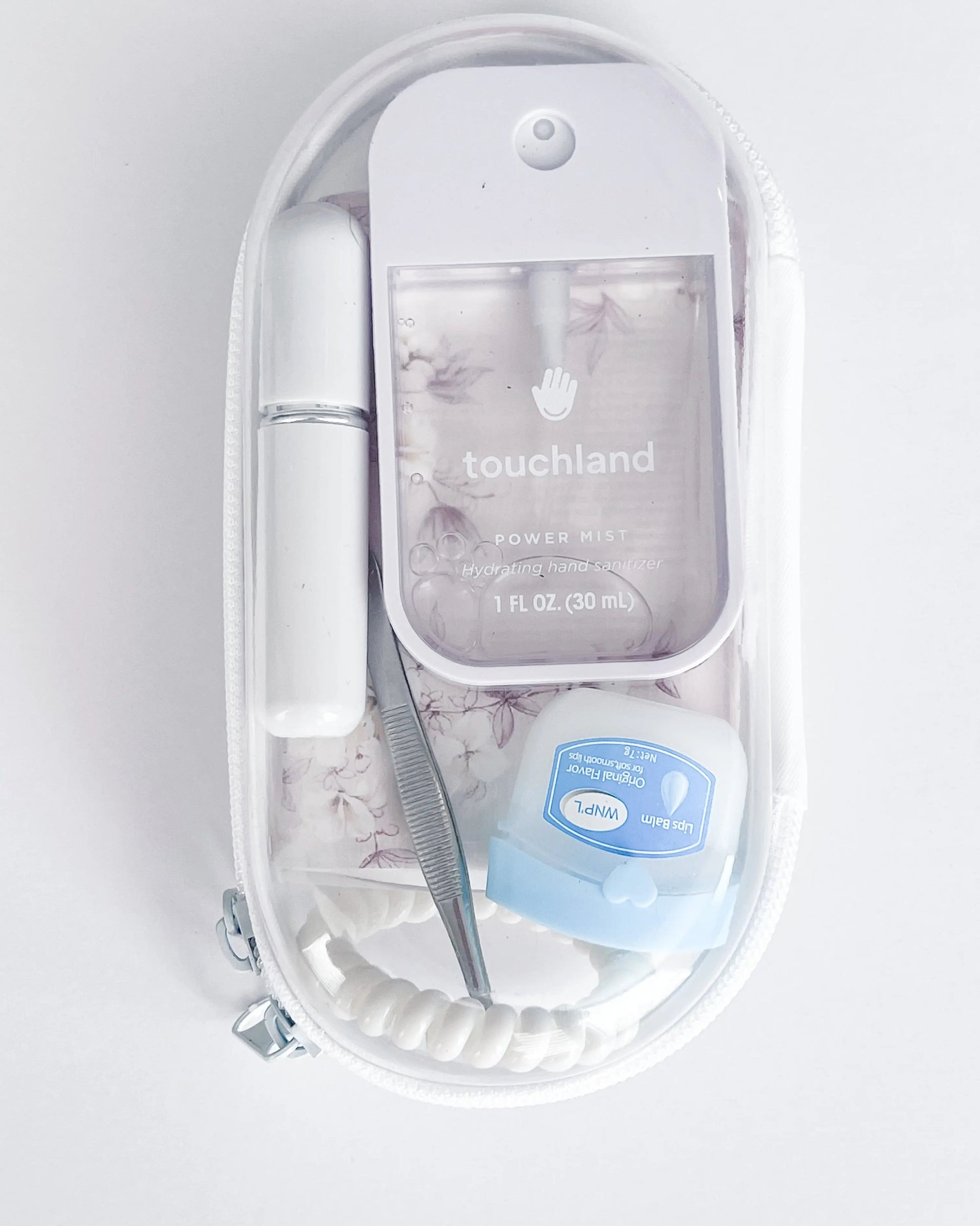 Everyday Essentials Kit filled with travel-size must-haves in white. 