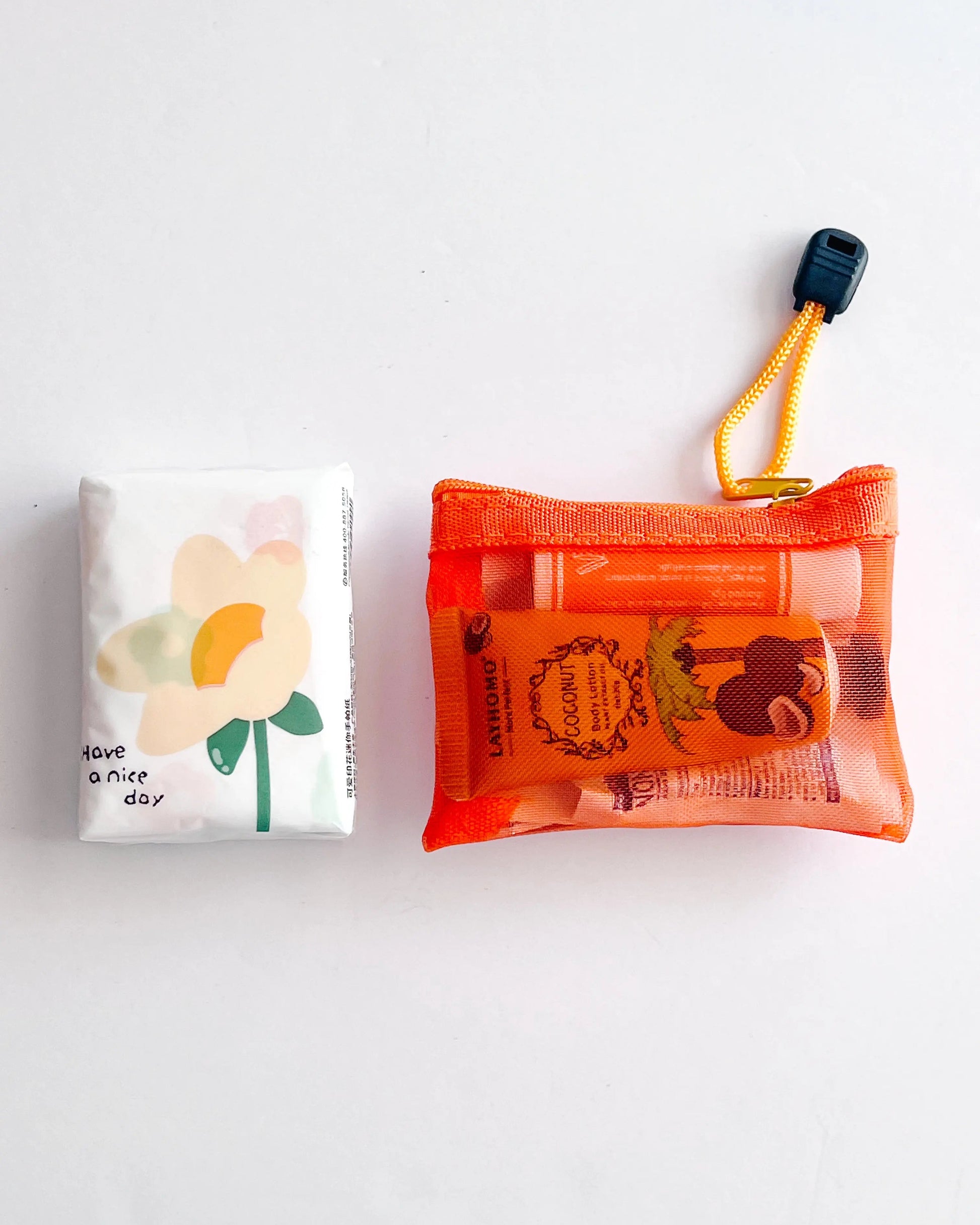 Compact Essential Pocket Kit flat lay with tissue pack and orange mesh pouch